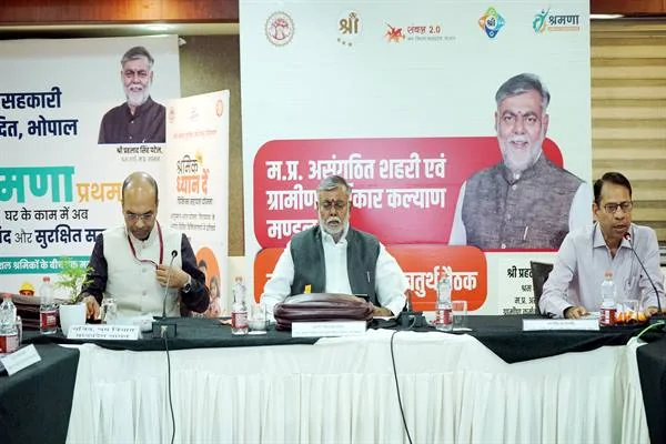 बैठक कक्ष में श्रम मंत्री और समिति सदस्य टी-शर्ट सम्मान के साथ खड़े हैं